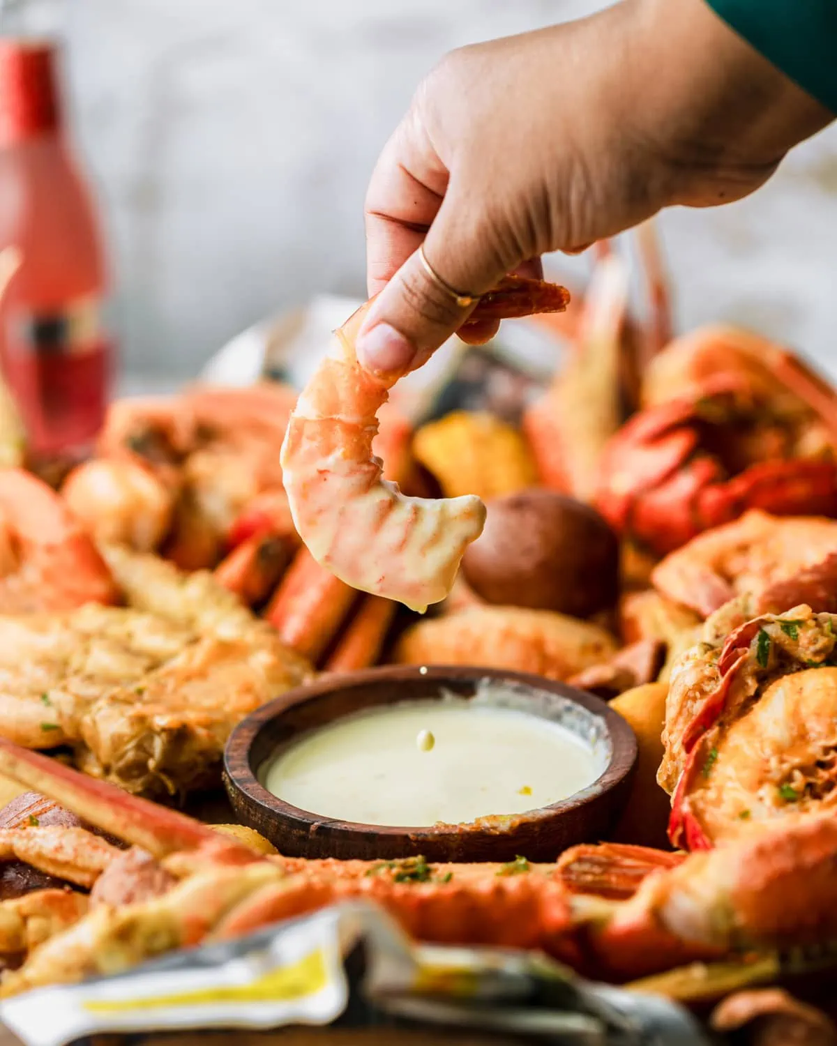 shrimp from a seafood boil being dipped in garlic butter